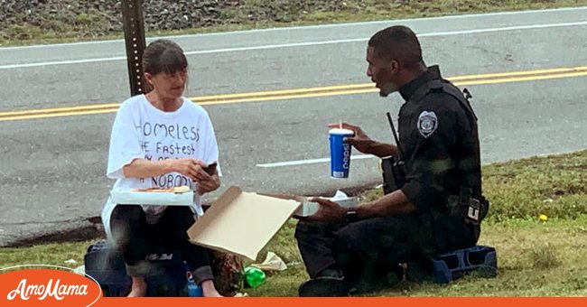 Un officier de police pris en photo assis à manger une pizza avec une femme sans-abris